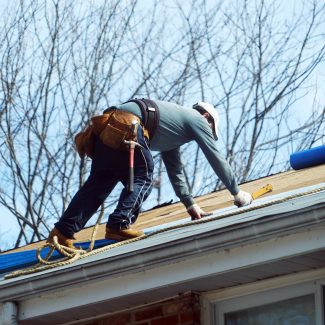 contractor installing and repairing new roof tiles